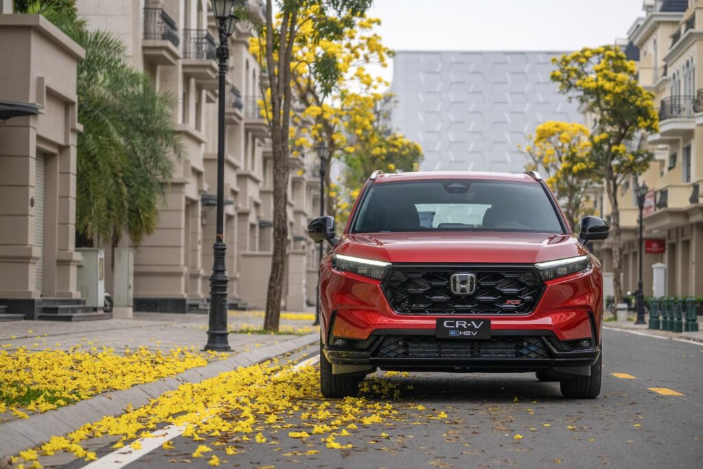 Đầu xe Honda CR-V e:HEV màu đỏ trên phố hoa vàng