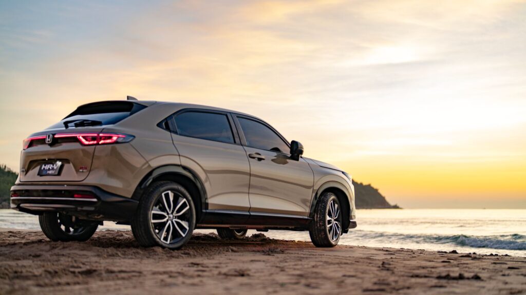 Honda HR-V màu be, góc 3/4 phía sau bên bờ biển